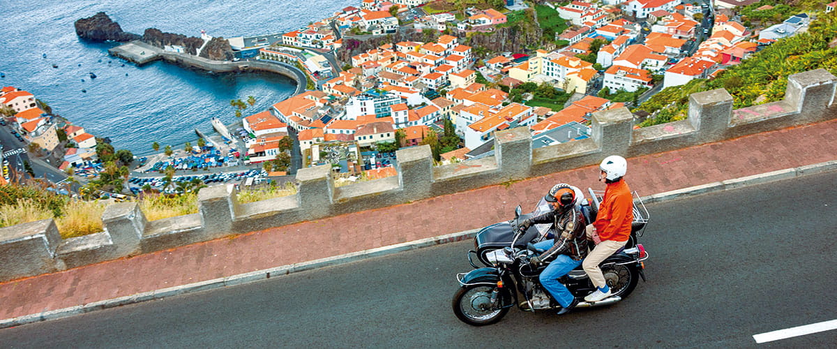 A motorcycle driving along the coastline of Funchal, Madeira
